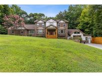 Charming two-story home with a brick facade, gabled roof, and well-manicured lawn at 3996 Spalding Ln, Atlanta, GA 30350