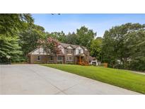 Charming brick home boasts a large front yard, long driveway, and basketball hoop at 3996 Spalding Ln, Atlanta, GA 30350
