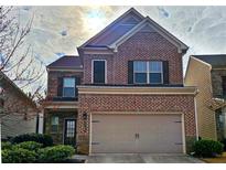 Traditional two-story brick home with an attached two-car garage and professionally landscaped yard at 1749 Charcoal Ives Rd, Lawrenceville, GA 30045