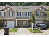 Charming townhome featuring a brick and shingle facade, attached garage, and well-maintained landscaping at 1559 Iris Walk, Jonesboro, GA 30238