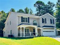 Charming two-story home with a brick facade, a covered porch, and an attached two-car garage at 2055 Deans Landing Dr, Lawrenceville, GA 30043
