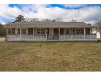 Charming brick home with a welcoming front porch and a well-maintained yard at 90 Harris Farm Rd, Dallas, GA 30157
