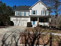 Charming two-story home features a welcoming front porch, well-maintained landscaping, and a two-car garage at 9137 Loxford St, Lithia Springs, GA 30122