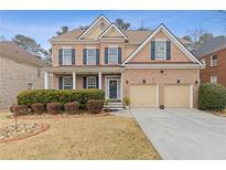 Charming two-story brick home with manicured front yard, two-car garage, and welcoming entrance at 3739 Newhalem Sw St, Atlanta, GA 30331