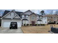 Beautiful two-story house with an attached two car garage and a stone facade entryway in a neighborhood setting at 2453 Wall Se St, Conyers, GA 30013