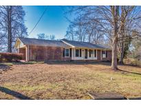 Charming brick home featuring a well-maintained front yard with mature trees and traditional architecture at 2826 Summit Ridge Dr, Marietta, GA 30066