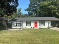 Charming one-story home boasts a bright red door, new paint, and a lush green lawn at 3042 Se Cottonwood Se Dr, Atlanta, GA 30316