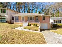 Charming brick home featuring a well-manicured front yard, a driveway, and mature trees at 664 Church Nw St, Atlanta, GA 30318