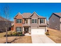 Charming two-story home featuring a brick and siding exterior, well-manicured lawn, and attached two-car garage at 5750 Palmtree Pass, Cumming, GA 30040