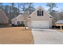 Charming single-story brick home with a two-car garage and well-maintained lawn at 106 Saint Margrit Cir, Stockbridge, GA 30281