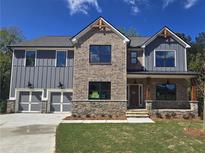 New two-story home with gray siding, stone accents, covered porch, and two-car garage at 3687 Thornhill Ct, Douglasville, GA 30135