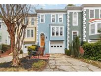Charming blue townhome featuring a front yard patio and attached single-car garage at 3783 Meeting St, Duluth, GA 30096