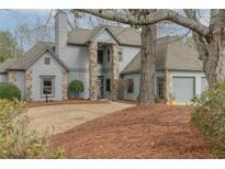 Charming home featuring stone accents, a two-car garage, and a well-maintained front yard at 10640 Branham Fields Rd, Johns Creek, GA 30097