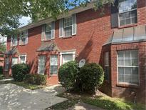 Charming townhome featuring a brick facade, bay windows, and well-maintained landscaping at 5768 Windgate Lane Ln, Lithonia, GA 30058