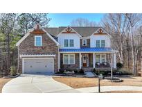 Beautiful two-story brick home with a blue porch roof and well-manicured lawn at 4032 Sweet Madison Pl, Suwanee, GA 30024