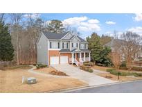Inviting two-story home with a brick and gray facade, a well-manicured lawn, and an attached two-car garage at 1657 Stilesboro Ridge Dr, Kennesaw, GA 30152