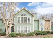 Charming two-story home with green siding, large windows, and well-maintained landscaping at 3205 Canyon Point Cir, Roswell, GA 30076