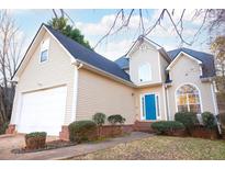 Inviting two-story home with a blue front door, attached garage and manicured landscaping at 20 Cascade Ct, Covington, GA 30016