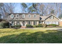 Charming two-story home featuring a well-manicured lawn and mature landscaping at 1903 Olde Village Run, Dunwoody, GA 30338