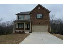 Charming two-story home with a brick front, a covered porch and an attached two-car garage at 5021 Falcon Pt, Douglasville, GA 30135