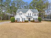 Charming two-story traditional home with a well-manicured front yard and mature trees at 4265 Elmhurst Ln, Cumming, GA 30028