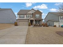 Charming two-story home featuring stone accents, neutral siding, and a well-manicured front lawn at 521 Flyingbolt Run, Canton, GA 30115