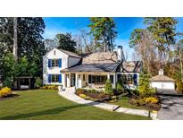 Charming white two-story home featuring blue shutters and a beautifully landscaped front yard at 660 Old Ivy Ne Rd, Atlanta, GA 30342