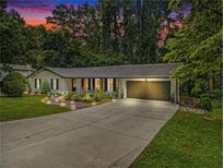 Charming home featuring a large driveway, attached garage, landscaped front yard and inviting front porch at 2810 Dunnington Cir Cir, Atlanta, GA 30341