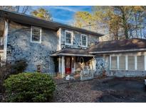 Quaint home featuring classic architecture, wood siding, bright red door and mature trees at 2057 Sugar Pike Rd, Woodstock, GA 30188