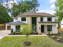 Stunning two-story home with a white exterior, stone accents, and lush landscaping, offering curb appeal at 401 Lynne Cir, Alpharetta, GA 30009