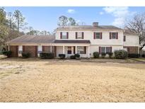 Inviting two-story house featuring red shutters, covered porch, and a spacious front yard at 2613 Stratford Ln, Morrow, GA 30260