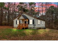 Charming one-story home with a cozy front porch and mature trees creating a serene atmosphere at 80 Holder St, Temple, GA 30179