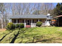 Charming single-story home with a cozy front porch and well-maintained lawn in a wooded neighborhood at 1045 Fincher Rd, Covington, GA 30016