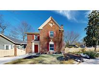 Charming red brick two-story home with red shutters, landscaped yard, and a bright blue sky at 1112 Austin Ne Ave, Atlanta, GA 30307