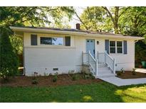 Charming home with a brick foundation, updated siding and blue front door at 3229 Mccauley Se Rd, Smyrna, GA 30080