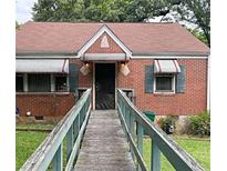 Charming brick home featuring a unique walkway, awning-covered windows and front door at 2628 Northview Ave, Decatur, GA 30032