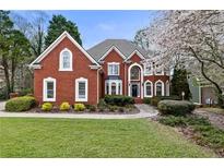 Beautiful brick home featuring manicured lawn, mature trees, and meticulous landscaping at 2260 Bent Creek Mnr, Alpharetta, GA 30005
