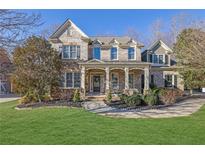 Beautiful two-story brick home with a manicured lawn and welcoming front porch at 4050 Preserve Crossing Ln, Cumming, GA 30040