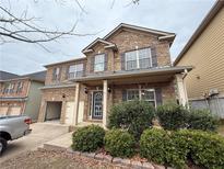 Charming two-story brick home with a covered front porch and attached two-car garage at 920 Sublime Trl, Canton, GA 30114
