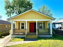 Charming yellow house with a cozy front porch, red door, and well-maintained lawn at 718 Dalvigney Nw St, Atlanta, GA 30318