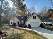 Charming single-Gathering home with a well-manicured lawn, attached garage, and beautiful landscaping at 3920 Knots Pass Rd, Snellville, GA 30039