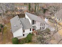 Aerial view of home featuring unique architectural design with a well-maintained roof and mature landscaping at 2667 Stonebrook Ne Ct, Roswell, GA 30075