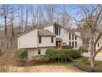 Attractive exterior elevation with multi-level roof, large windows, and mature landscaping at 2667 Stonebrook Ne Ct, Roswell, GA 30075