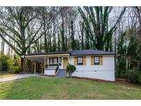 Charming single-story home featuring a covered porch and freshly painted exterior with decorative window shutters at 2895 Akron St, Atlanta, GA 30344