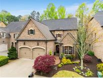 Charming brick home with a two-car garage, manicured landscaping, and mature trees at 3121 Haynesbrooke Ln, Alpharetta, GA 30022