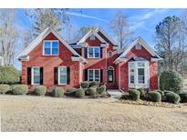 Charming red brick home with a well-manicured lawn and mature landscaping at 6365 Rutherford Pl, Suwanee, GA 30024