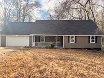 Charming single-story home with a covered porch, a two-car garage, and attractive neutral-toned siding at 25 Oak Crest Ct, Covington, GA 30016