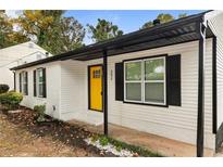 Charming home with a bright yellow front door and black shutters at 3475 Meadowlane Sw Pl, Atlanta, GA 30331