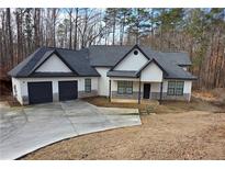 Beautifully designed home with attached garage, a manicured lawn, and a welcoming front porch at 5264 Prestley Crossing Ln, Douglasville, GA 30135