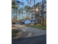 A sprawling home with a long driveway nestled among mature pine trees at 135 Windy Hill Rd, Fayetteville, GA 30214